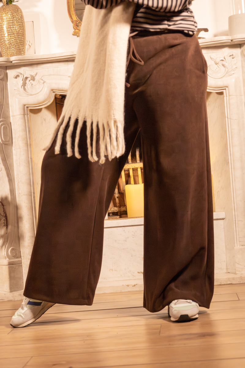 Bruine wijde broek met casual stijl, gecombineerd met een witte sjaal.