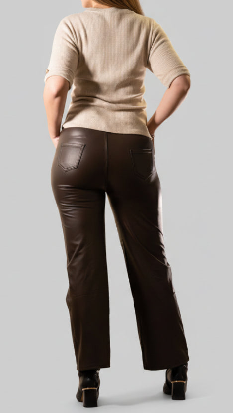 Zwarte leren palazzobroek gedragen door model, stijlvolle feestoutfit met kerstdecoratie.