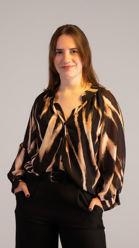 Zwart shirt met een abstracte print, casual stijl, gedragen door een model bij een kerstboom.