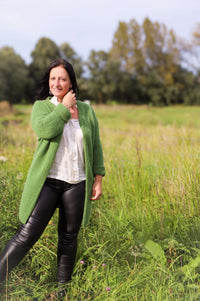 Model draagt hier lange groene gilet van Terra di Siena met stoere leatherlookbroek