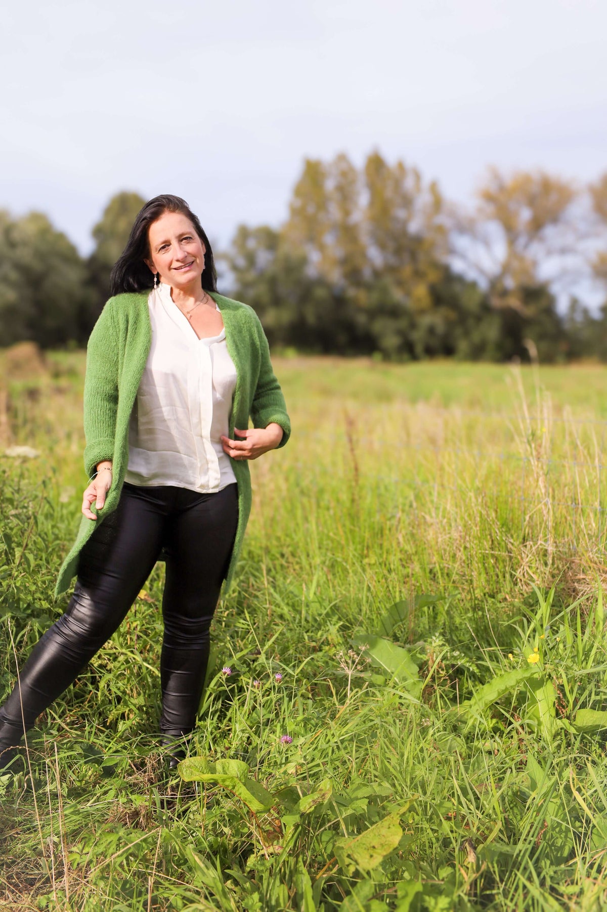 Model draagt hier lange groene gilet van Terra di Siena met stoere leatherlookbroek