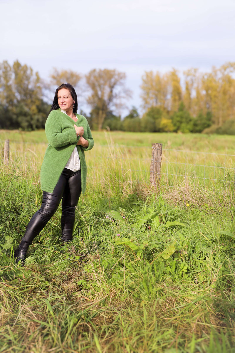 Model draagt hier lange groene gilet van Terra di Siena met stoere leatherlookbroek