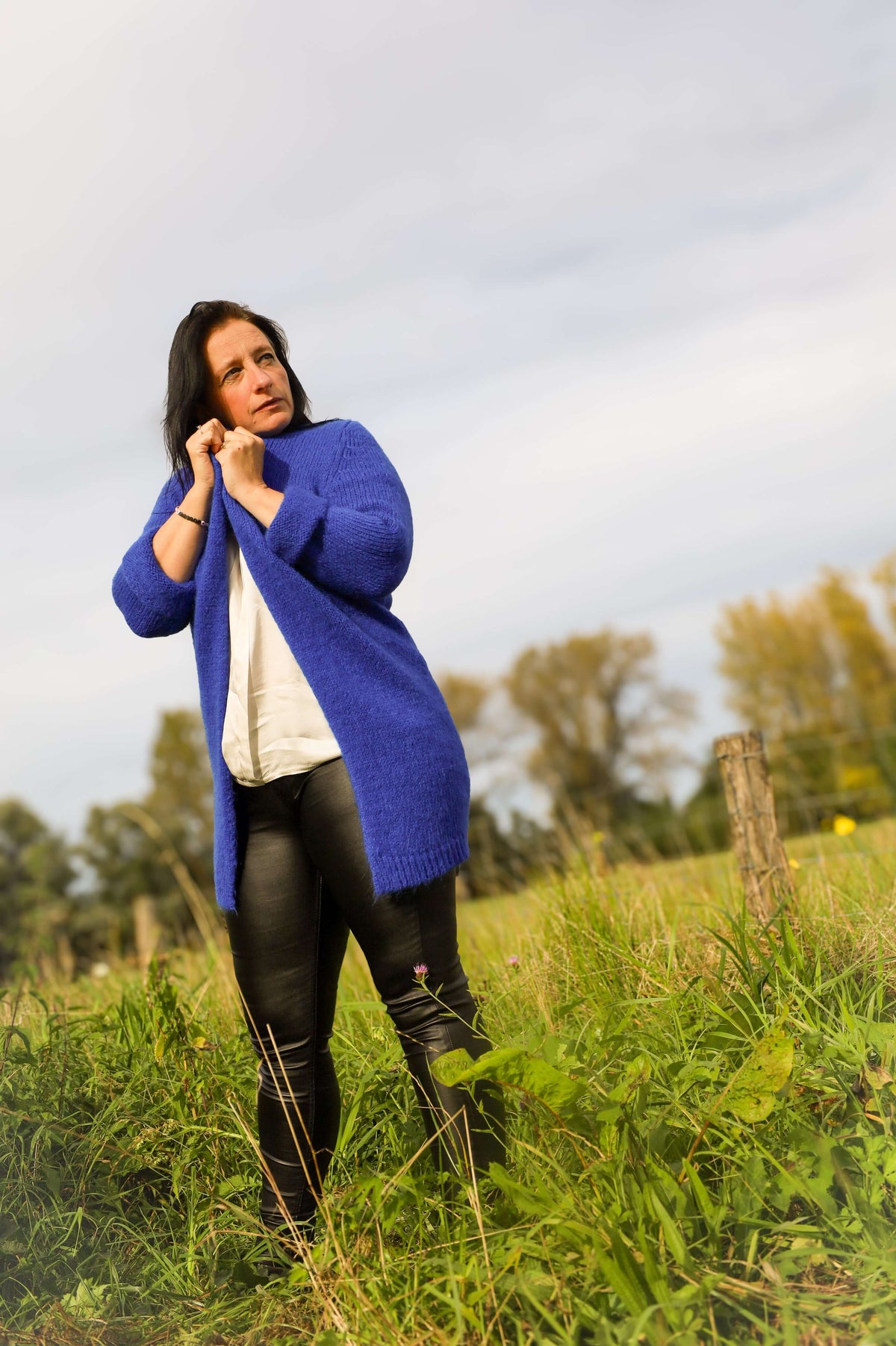 Model draagt kobaltblauw lange gilet van Terra di Siena met stoere leatherlookbroek.