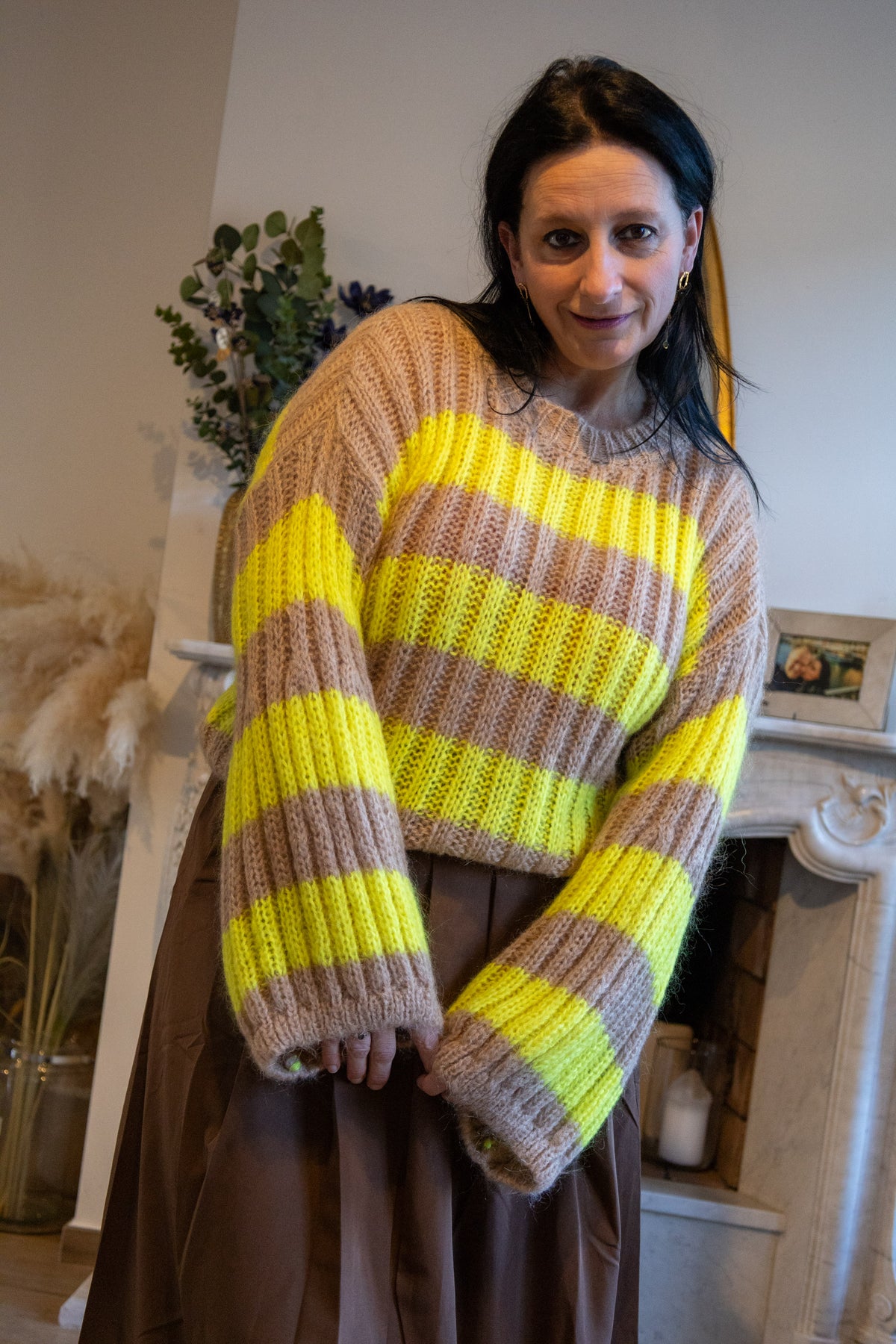 Kleurige gebreide trui met gele en bruine strepen, casual stijl, gecombineerd met een bruine rok.