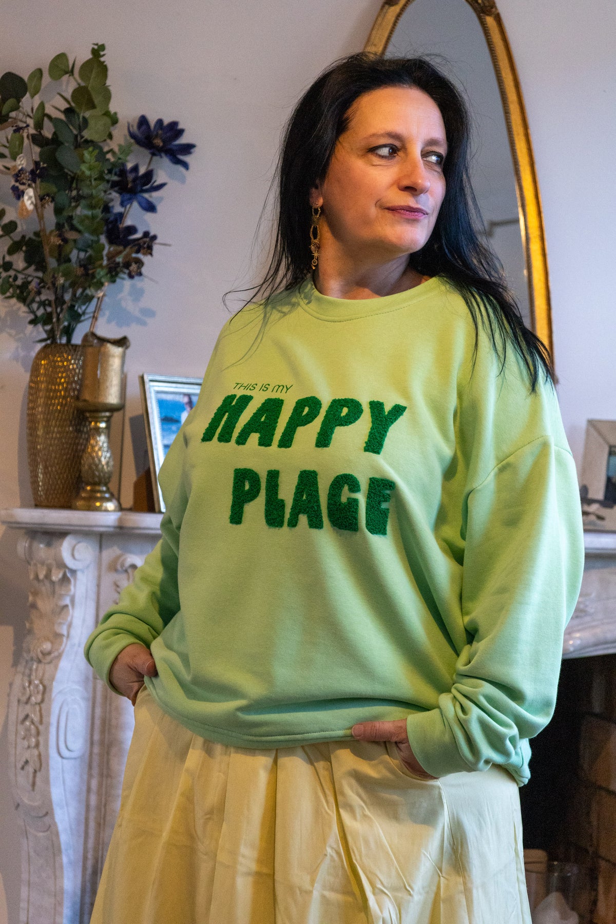 Groene sweater met de tekst 'THIS IS MY HAPPY PLACE' en gele rok, stijlvolle casual outfit.