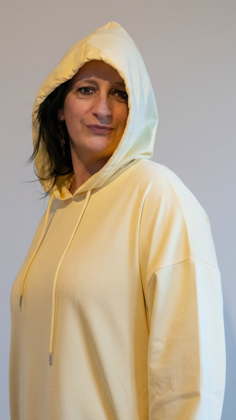 Lichte gele oversized hoodie, casual stijl, gedragen door model met een kap.