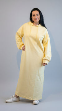 Lichtgele oversized hoodie jurk model in casual stijl, met witte sneakers.