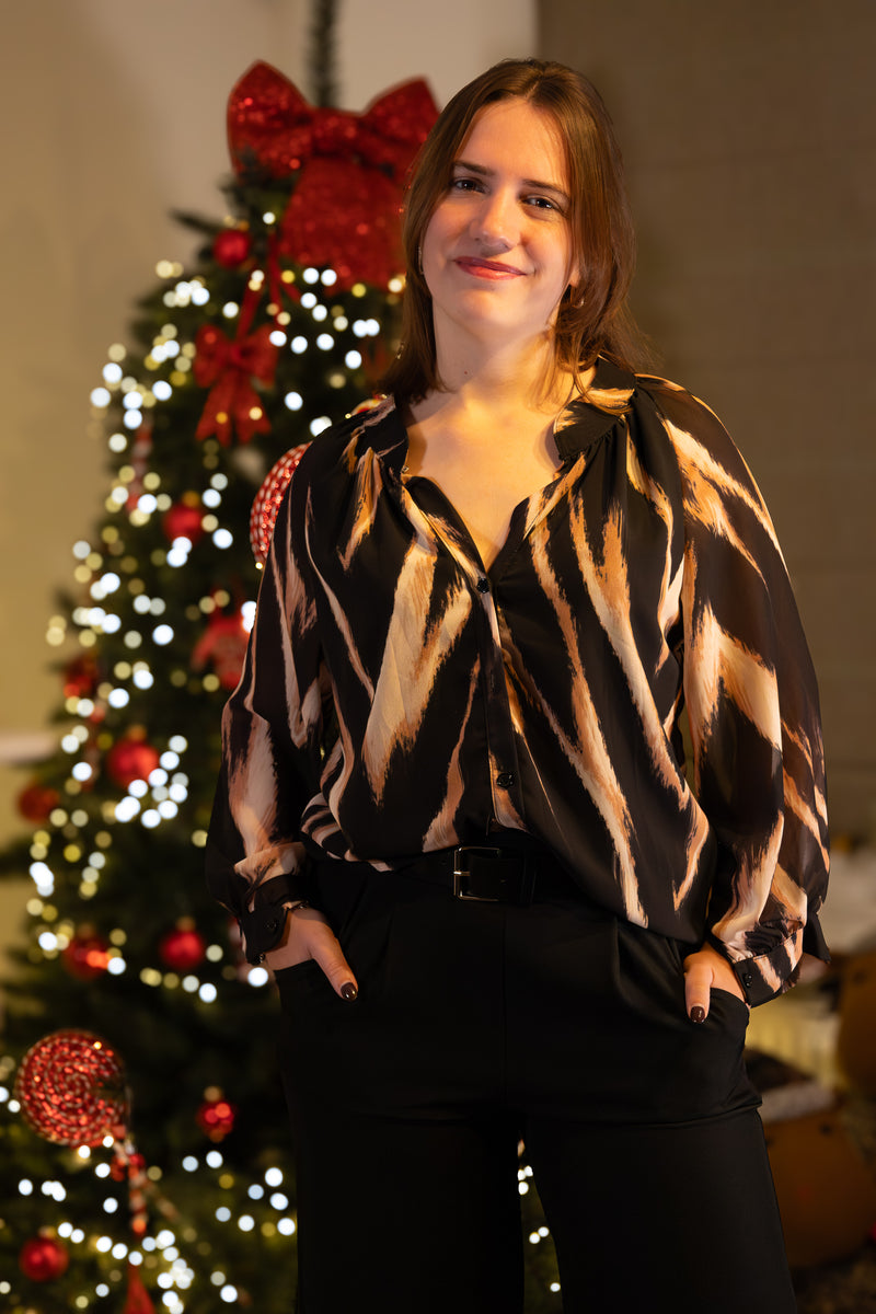 Zwarte blouse met abstracte print, casual chic stijl, model met handen in de zakken