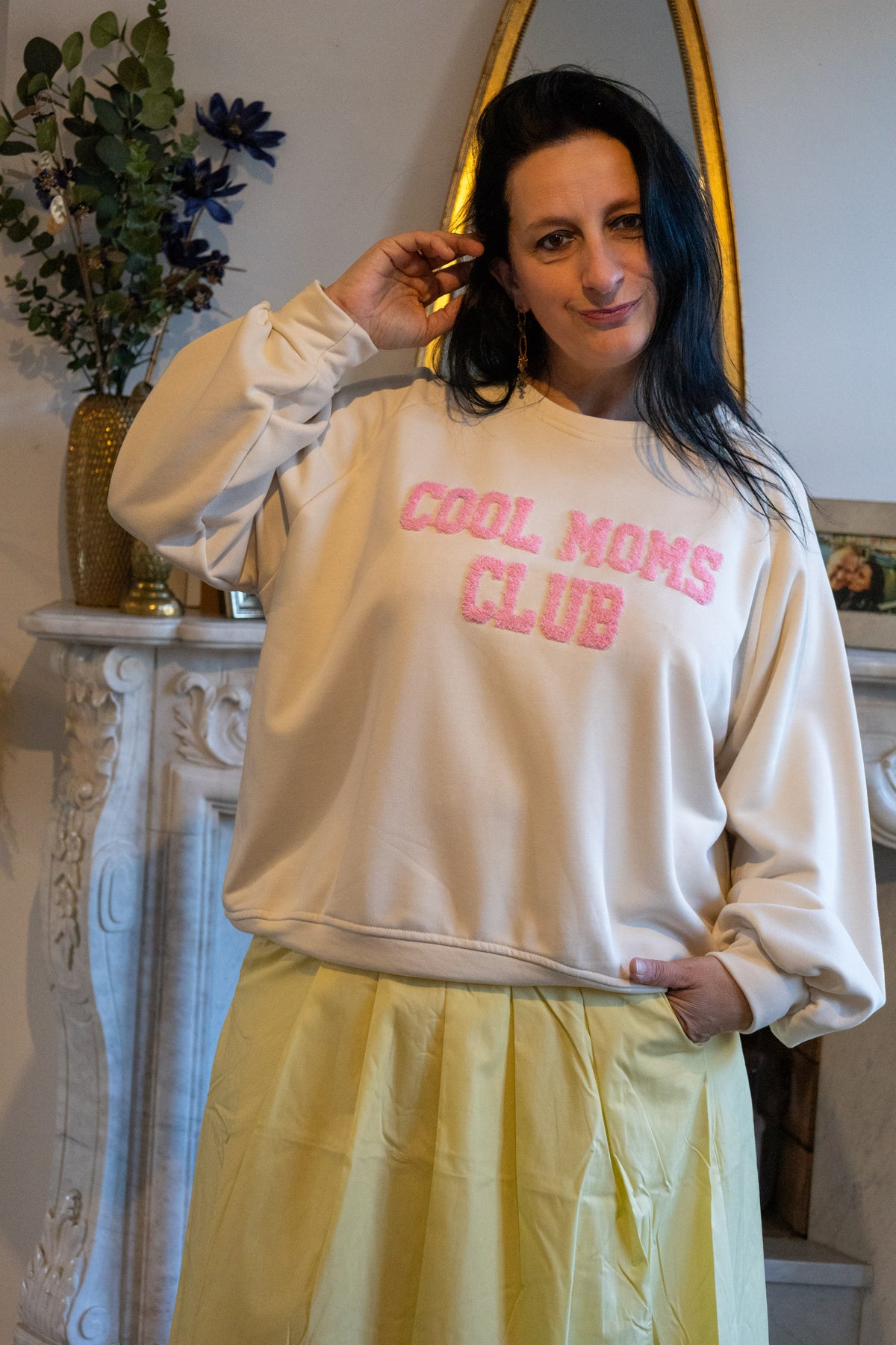 Zachte crème sweatshirt met roze opdruk 'Cool Moms Club' en gele plissérok.