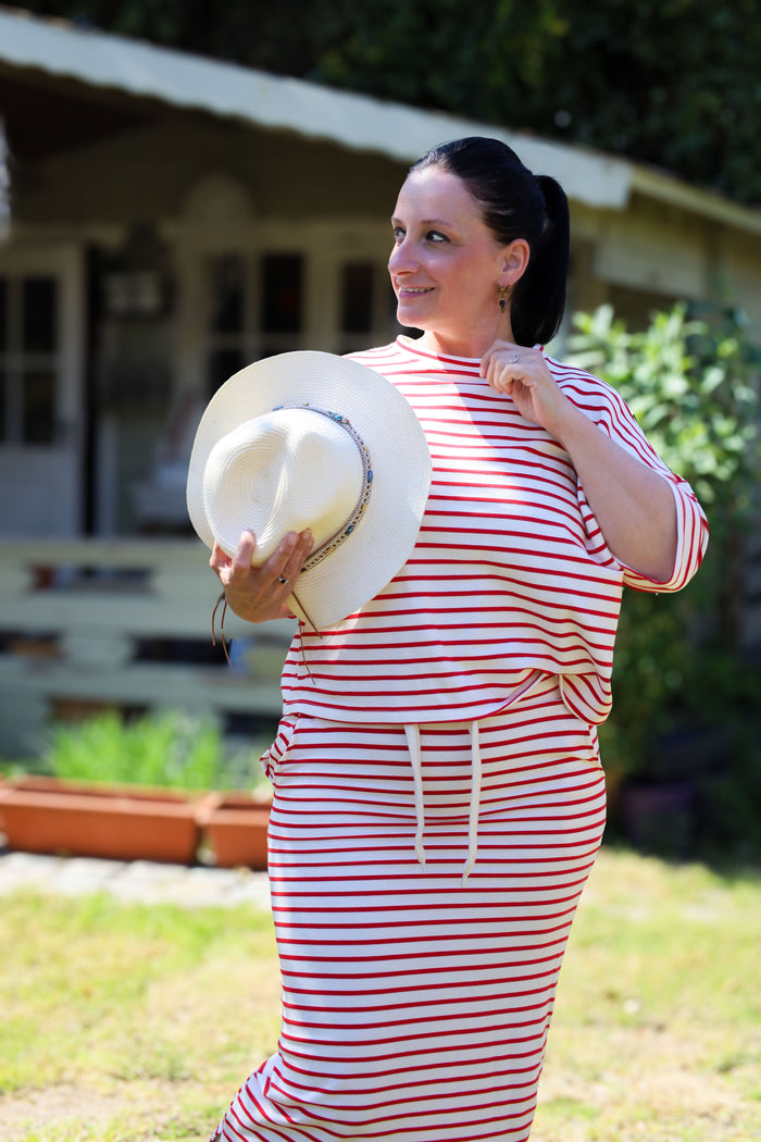 Lichte T-shirt top in rood-witte streep met een rechte, losse pasvorm. Casual en fris, perfect te combineren met de bijpassende rok.