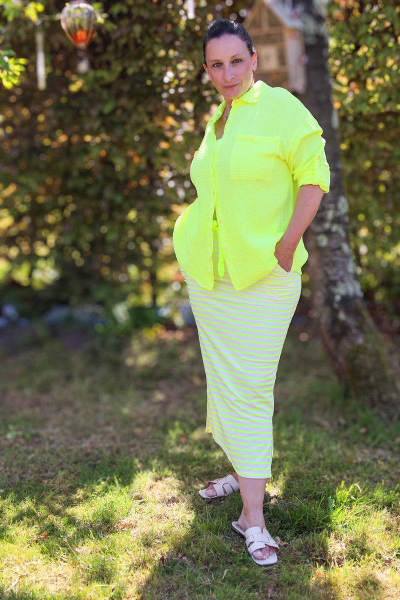 Comfortabele stretchrok met neongele en beige strepen, trekkoord en zijzakken. Sportief, flatterend en zomers casual.