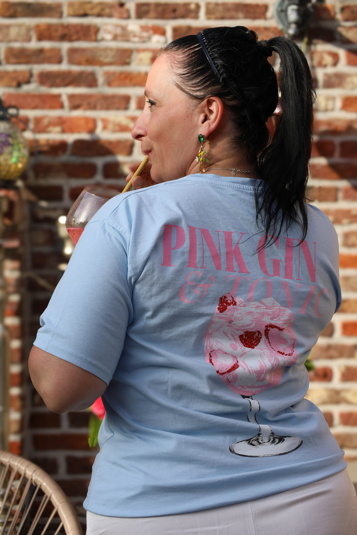 Lichtblauw T-shirt met zomerse “Pink Gin & Tonic” opdruk op de rug. Casual, comfy en ideaal voor aperitiefmomenten in stijl.