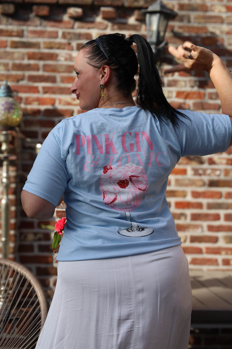 Lichtblauw T-shirt met zomerse “Pink Gin & Tonic” opdruk op de rug. Casual, comfy en ideaal voor aperitiefmomenten in stijl.