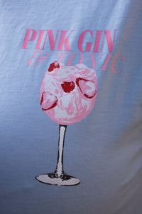 Lichtblauw T-shirt met zomerse “Pink Gin & Tonic” opdruk op de rug. Casual, comfy en ideaal voor aperitiefmomenten in stijl.