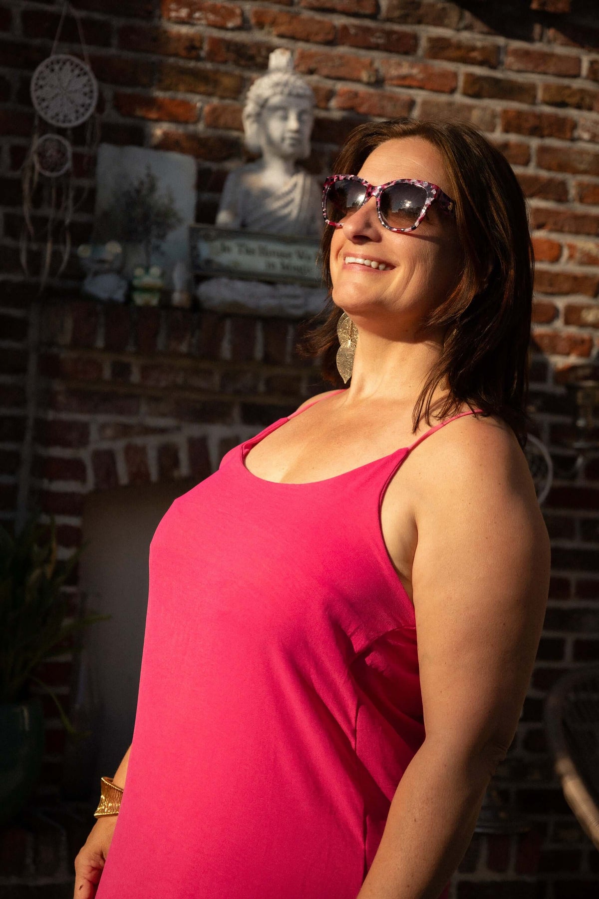 Terra di Siena jurk fuchsia, strapless maxi-jurk, vrouw in een levendige fuchsia jurk met zonnebril.