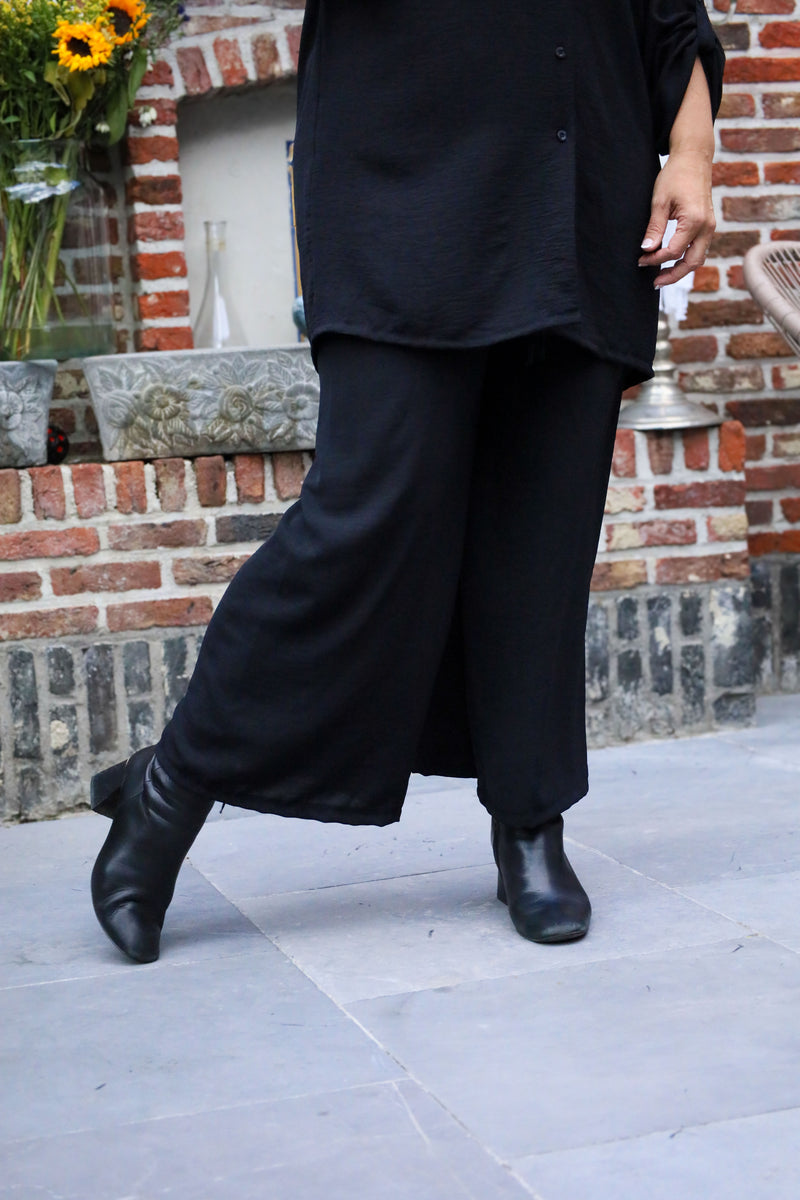 Zwarte broek met elastische taille en striklint, soepel vallende stof – She&Me damesmode Duffel, Lier, Mechelen.