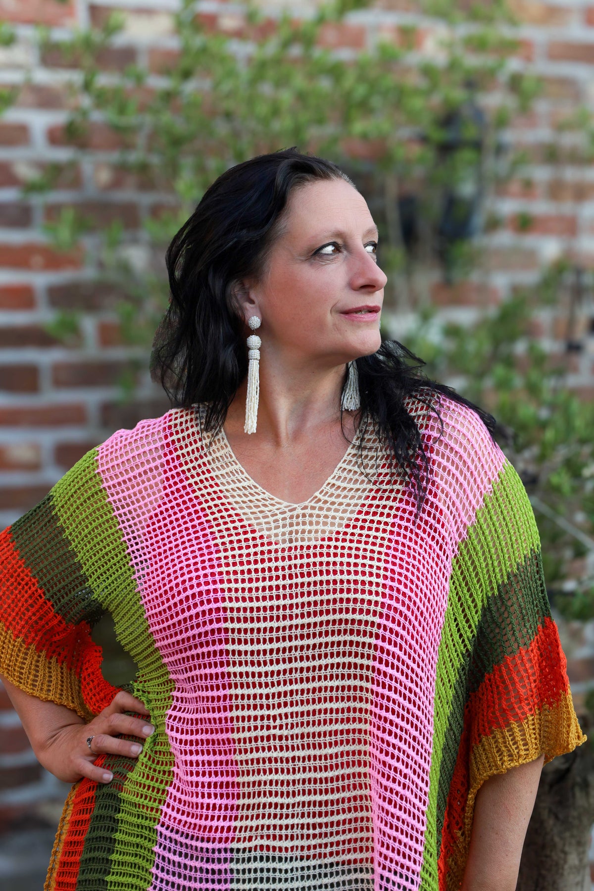Kleurrijke gehaakte poncho voor dames, one-size maat 40-48, met franjes, gefotografeerd in tuinsetting – damesmode Duffel