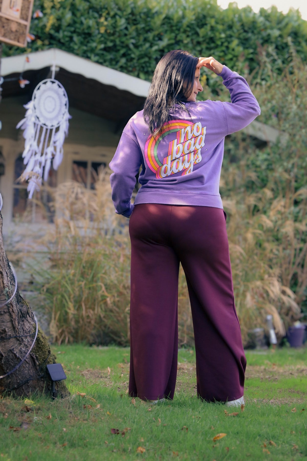 Vrouw draagt lila Dolci Giorni sweater met roze ‘No Bad Days’-print – casual damesmode bij She&Me Duffel.