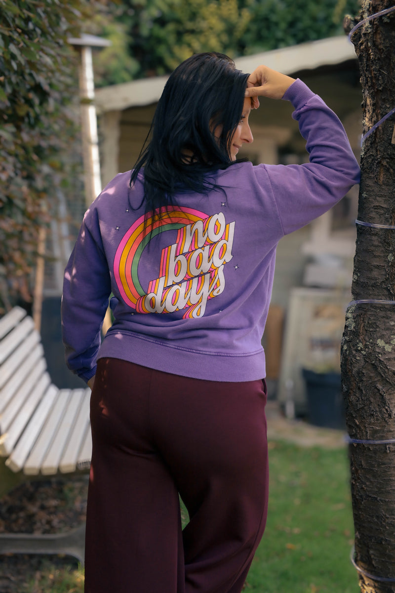 Vrouw draagt lila Dolci Giorni sweater met roze ‘No Bad Days’-print – casual damesmode bij She&Me Duffel.