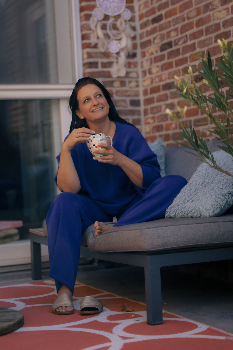 Vrouw poseert in kobaltblauwe  Dolci Giorni set met losse top en broek – comfortabele damesmode bij She&Me Duffel.