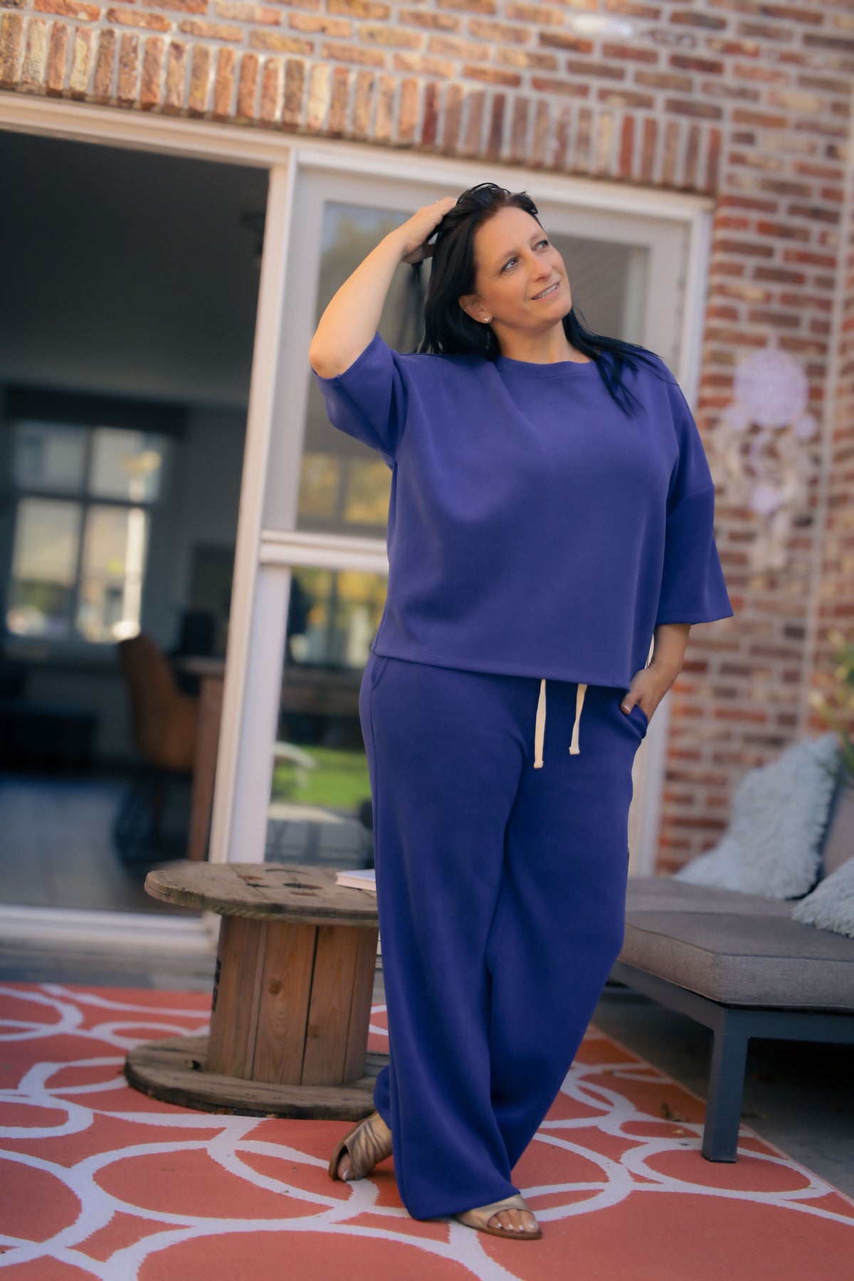 Vrouw poseert in kobaltblauwe  Dolci Giorni set met losse top en broek – comfortabele damesmode bij She&Me Duffel.