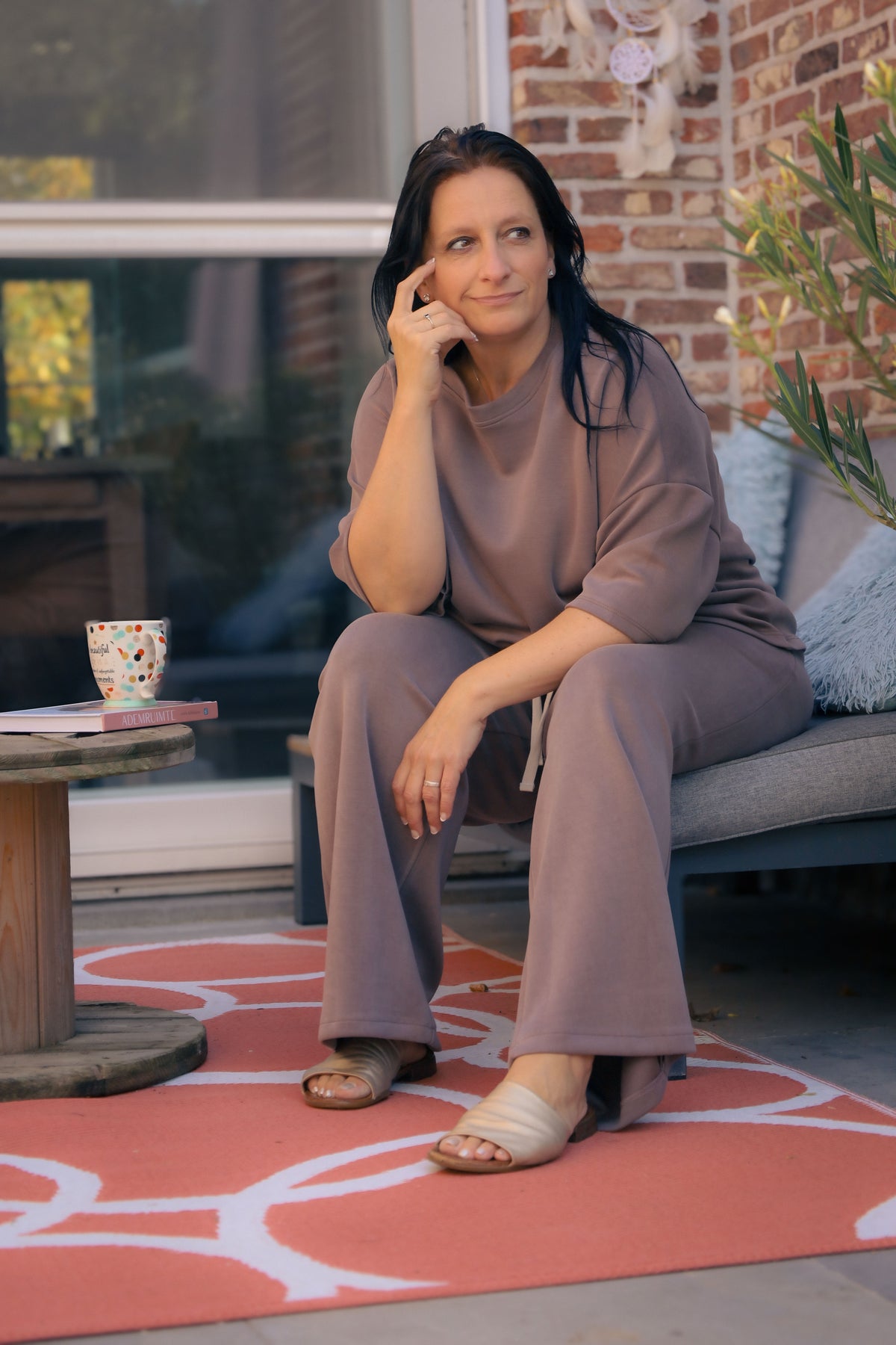 Vrouw poseert in taupe kleurige  Dolci Giorni set met losse top en broek – comfortabele damesmode bij She&Me Duffel.