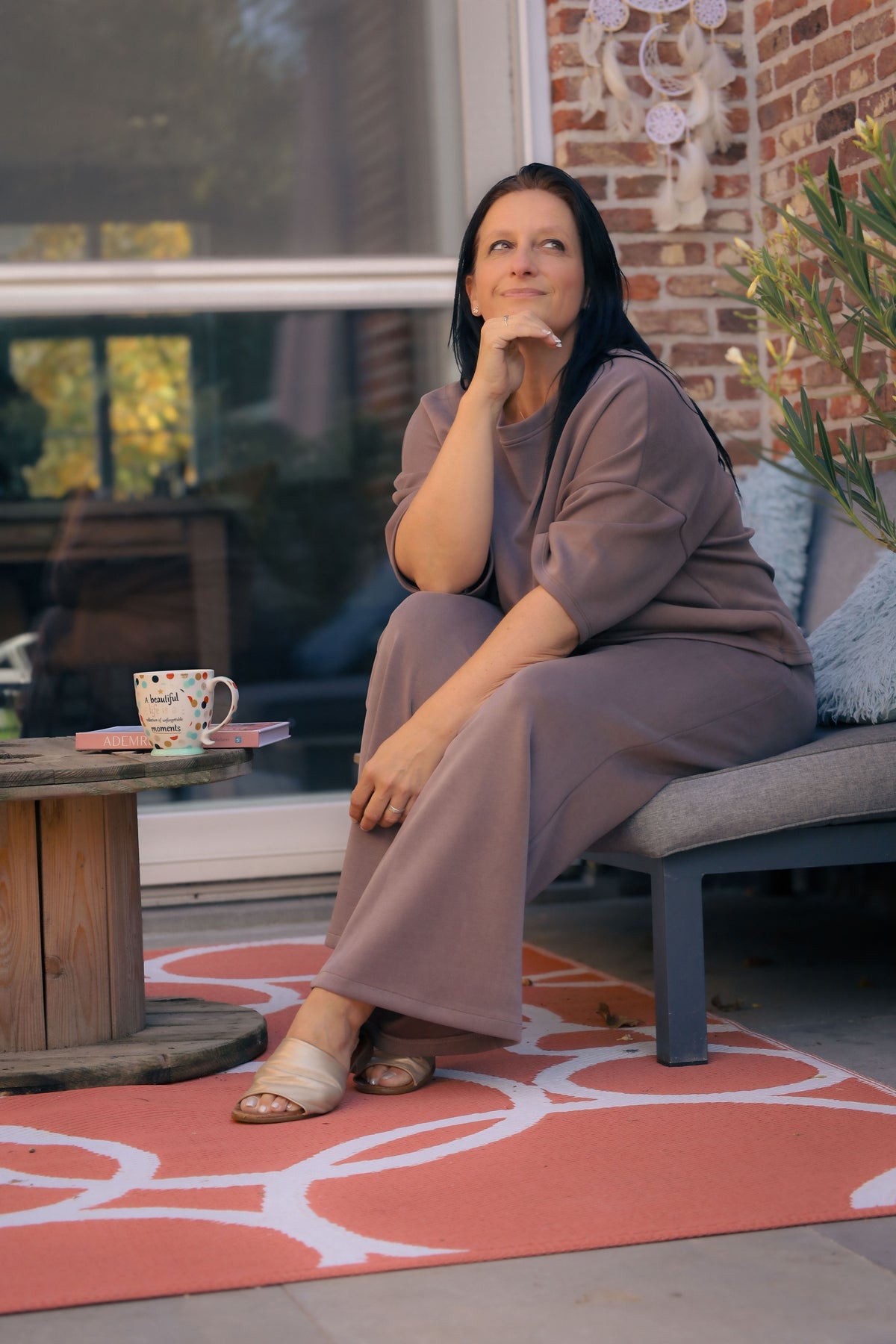 Vrouw poseert in taupe kleurige  Dolci Giorni set met losse top en broek – comfortabele damesmode bij She&Me Duffel.