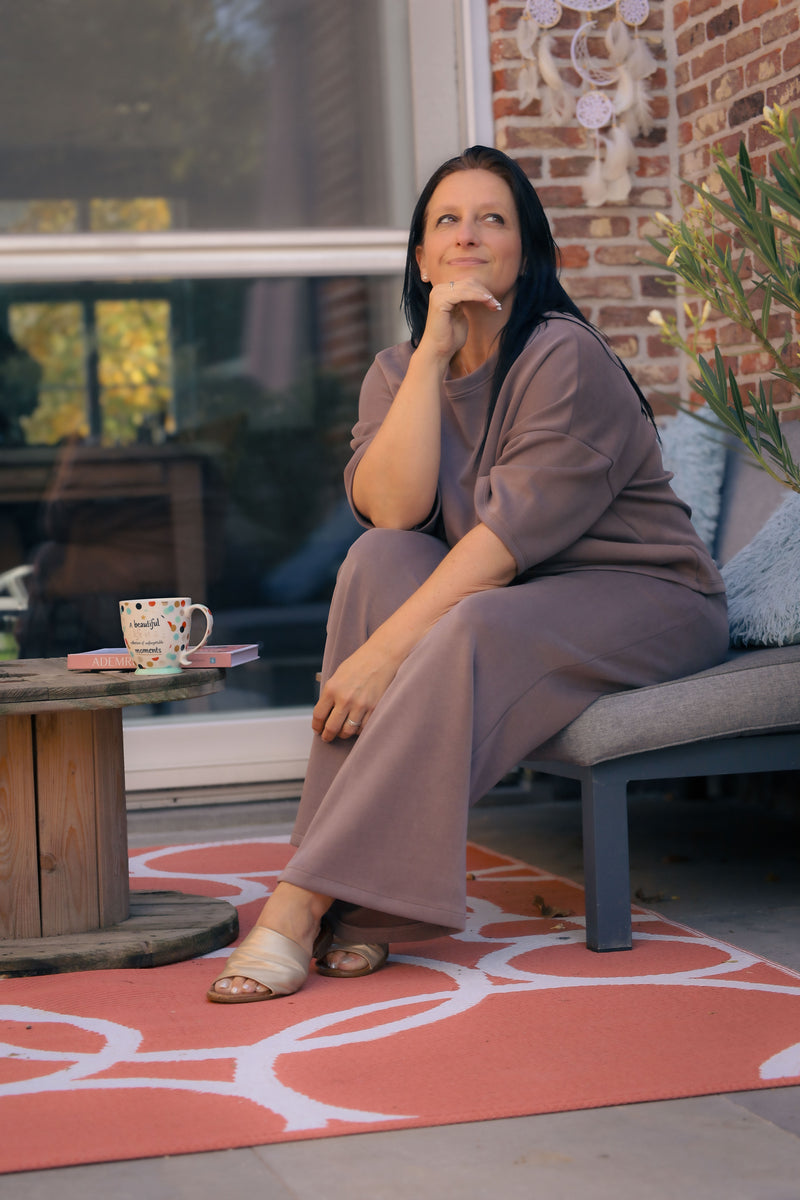 Vrouw poseert in taupe kleurige  Dolci Giorni set met losse top en broek – comfortabele damesmode bij She&Me Duffel.