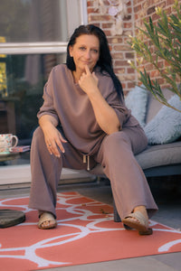 Vrouw poseert in taupe kleurige  Dolci Giorni set met losse top en broek – comfortabele damesmode bij She&Me Duffel.