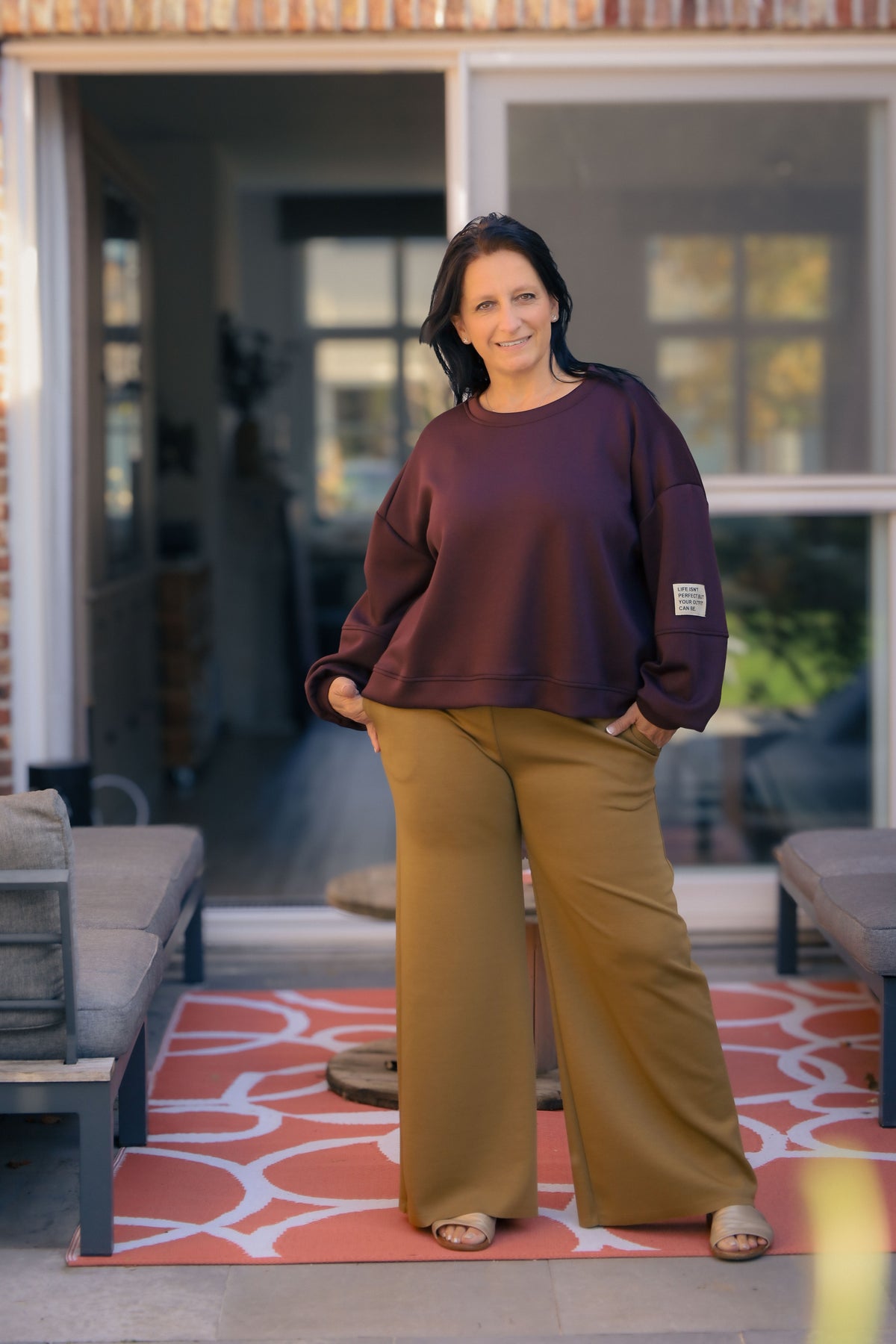 Vrouw draagt korte bordeauxrode Dolci Giorni trui met losse pasvorm – damesmode bij She&Me Duffel.