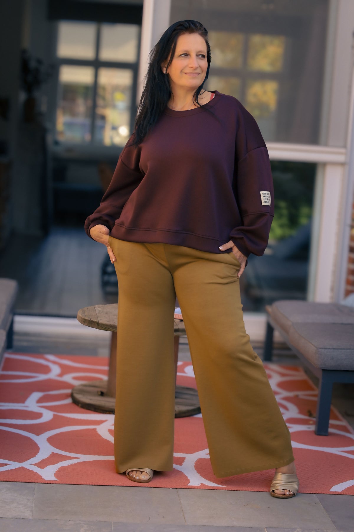 Vrouw draagt korte bordeauxrode Dolci Giorni trui met losse pasvorm – damesmode bij She&Me Duffel.