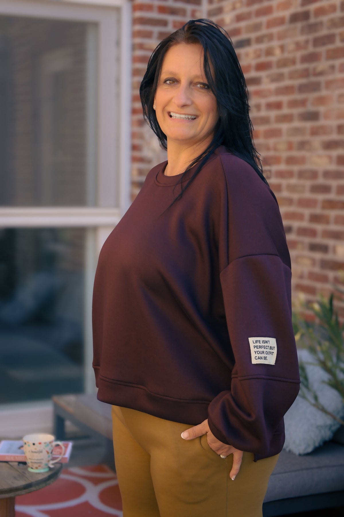 Vrouw draagt korte bordeauxrode Dolci Giorni trui met losse pasvorm – damesmode bij She&Me Duffel.