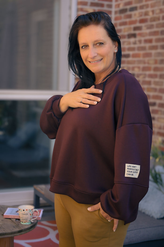 Vrouw draagt korte bordeauxrode Dolci Giorni trui met losse pasvorm – damesmode bij She&Me Duffel.