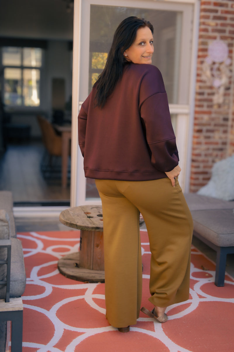 Vrouw draagt korte bordeauxrode Dolci Giorni trui met losse pasvorm – damesmode bij She&Me Duffel.