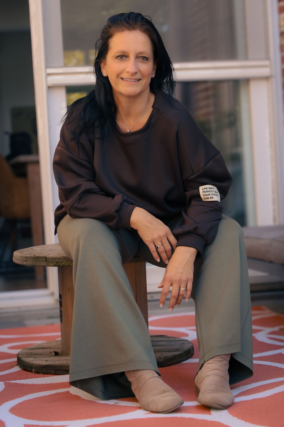 Vrouw draagt korte zwarte Dolci Giorni trui met losse pasvorm – damesmode bij She&Me Duffel.