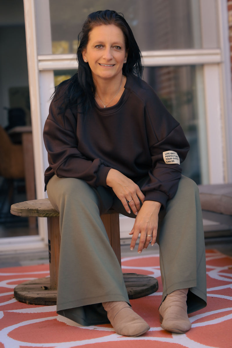 Vrouw draagt korte zwarte Dolci Giorni trui met losse pasvorm – damesmode bij She&Me Duffel.