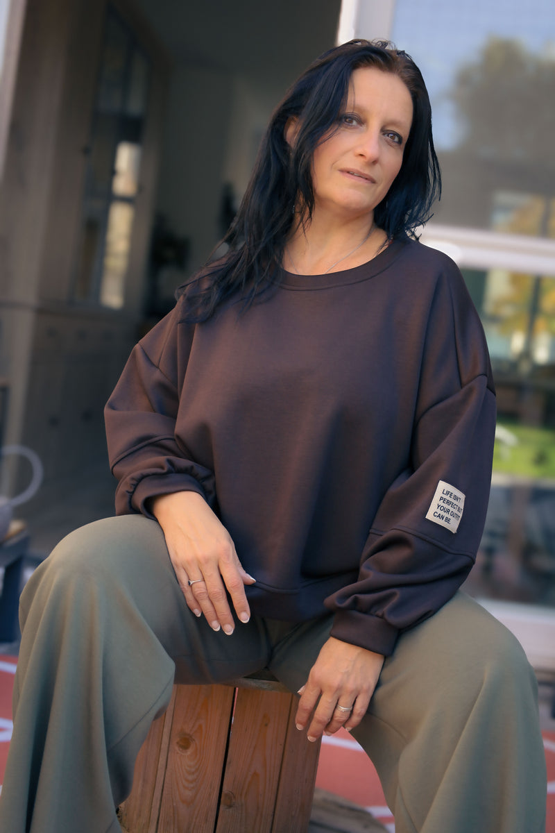 Vrouw draagt korte zwarte Dolci Giorni trui met losse pasvorm – damesmode bij She&Me Duffel.