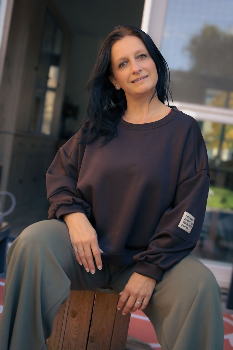 Vrouw draagt korte zwarte Dolci Giorni trui met losse pasvorm – damesmode bij She&Me Duffel.