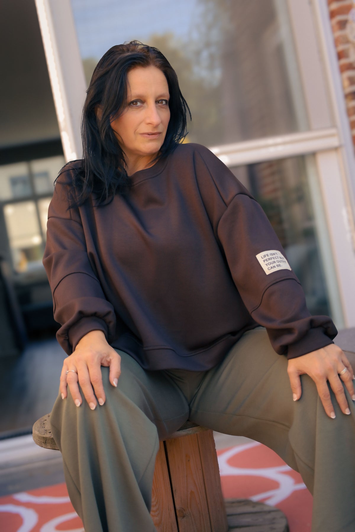 Vrouw draagt korte zwarte Dolci Giorni trui met losse pasvorm – damesmode bij She&Me Duffel.