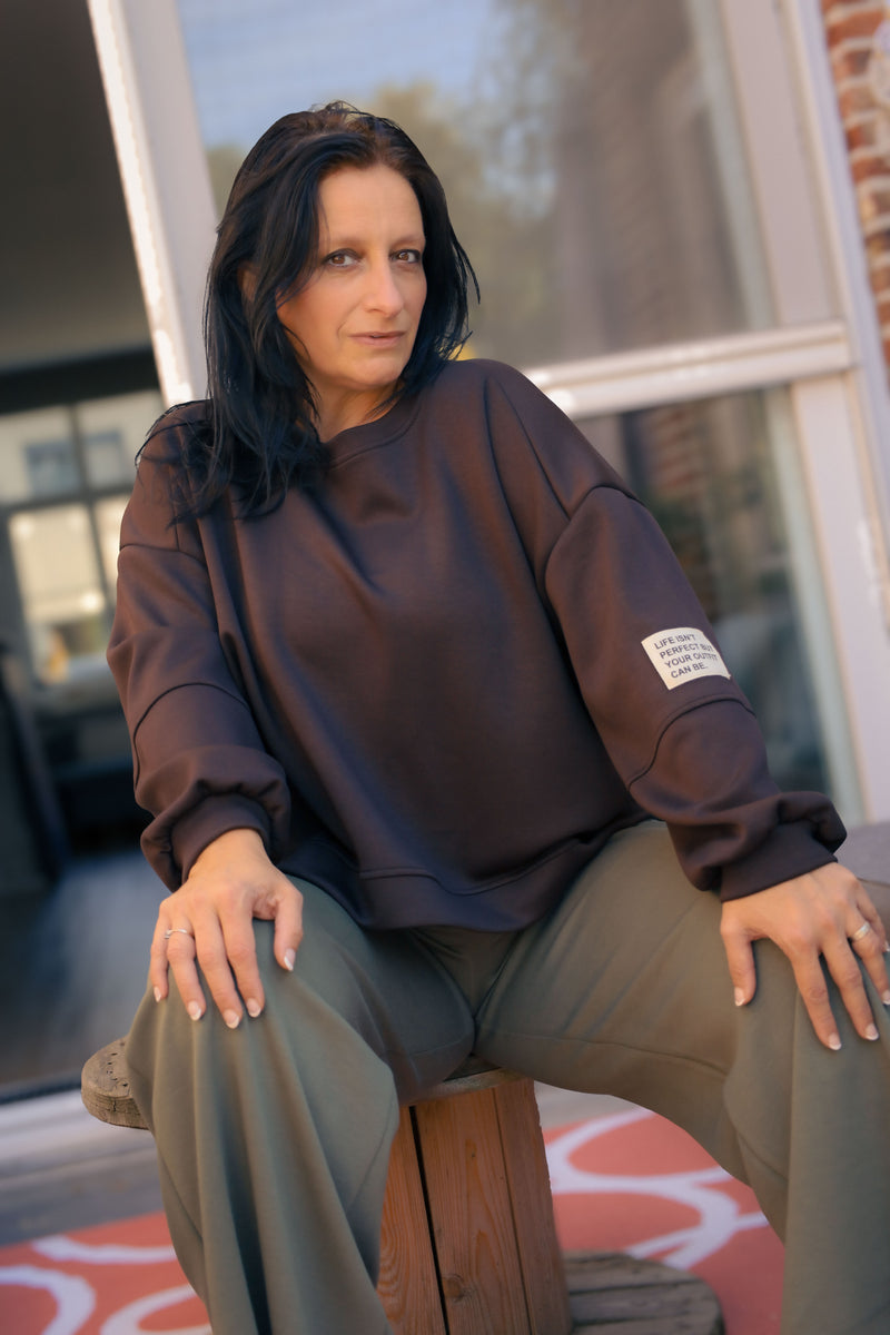 Vrouw draagt korte zwarte Dolci Giorni trui met losse pasvorm – damesmode bij She&Me Duffel.