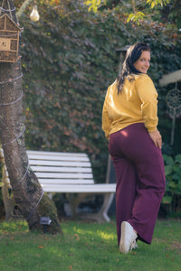 Vrouw draagt mosterdgele Dolci Giorni sweater met ‘Prosecco Mood’-print – comfortabele damesmode bij She&Me Duffel.