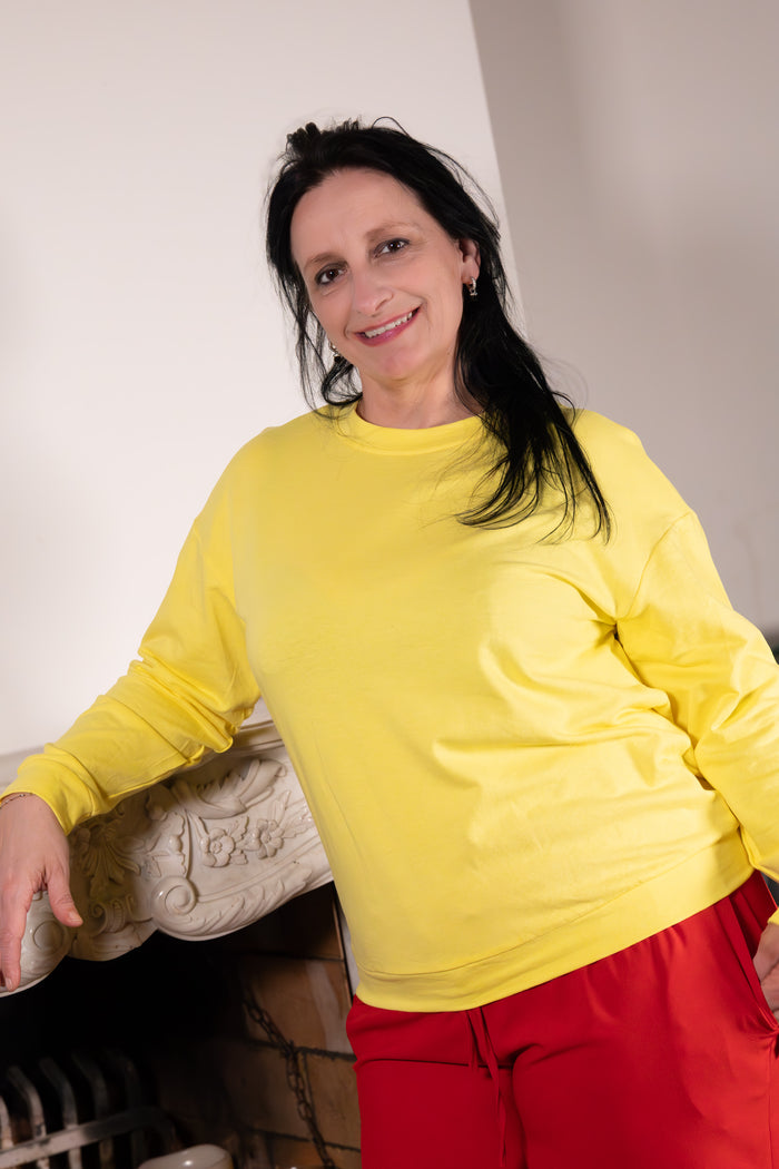 GOOD VIBES  – gele sweater met kleurrijke print, vrouw in gele sweater, casual en trendy look.