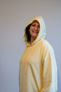 Gele oversized hoodie gedragen door vrouw, casual en comfortabel uiterlijk.
