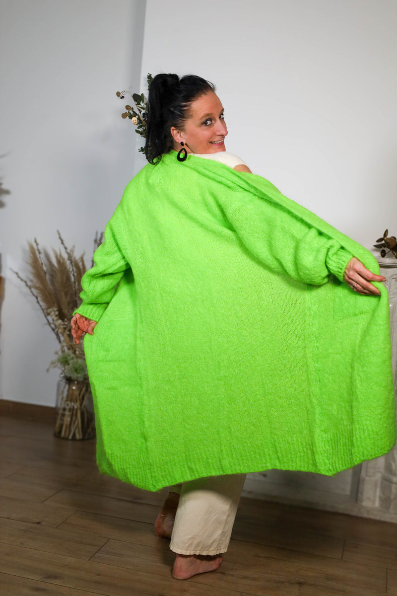 Vrouw draagt een oversized groene cardigan, geschikt voor casual en stijlvolle combinaties.