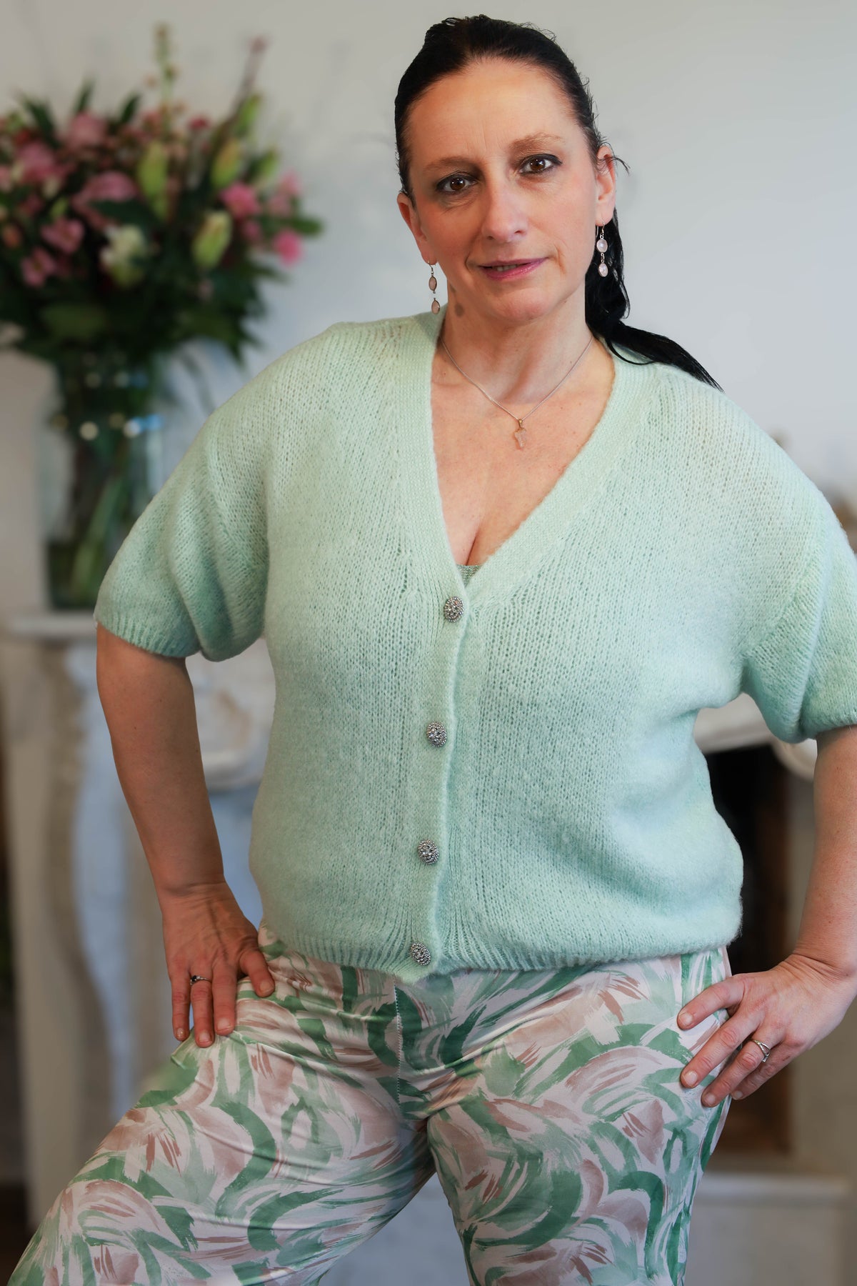 Model draagt mintgroene zachte gilet met knopen op een losse printbroek