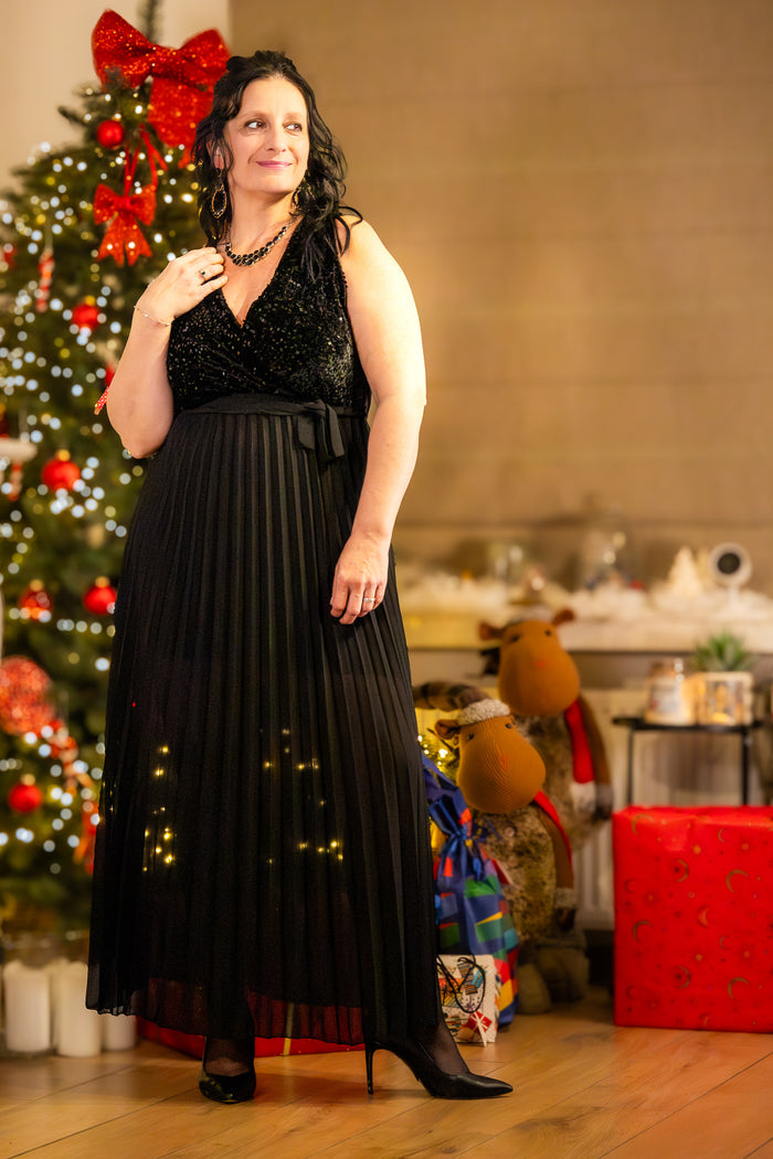 Zwarte avondjurk met pailletten, elegant en feestelijk, gedragen voor kerstdecoratie.