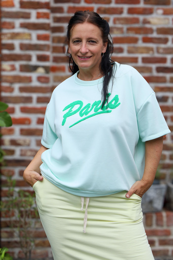 vrouw draagt mintgroen T-shirt met Paris-opdruk uit de La Dolce Vita collectie – dameskleding Duffel

