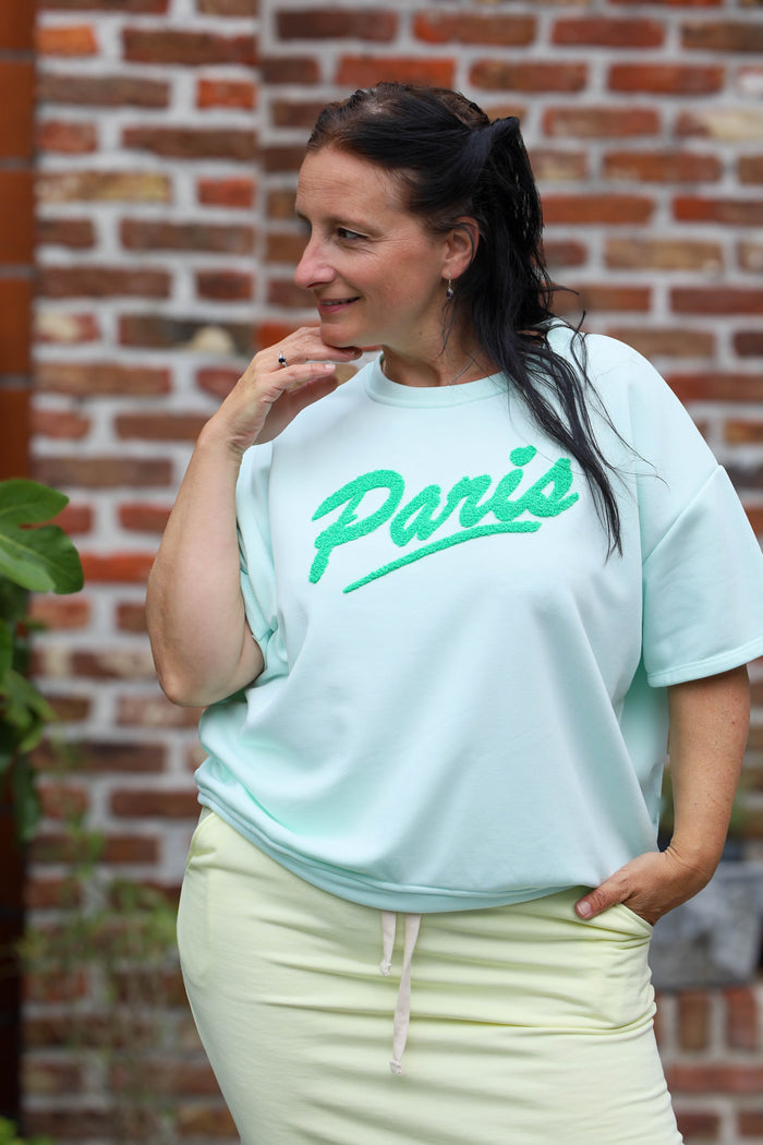 vrouw draagt mintgroen T-shirt met Paris-opdruk uit de La Dolce Vita collectie – dameskleding Duffel

